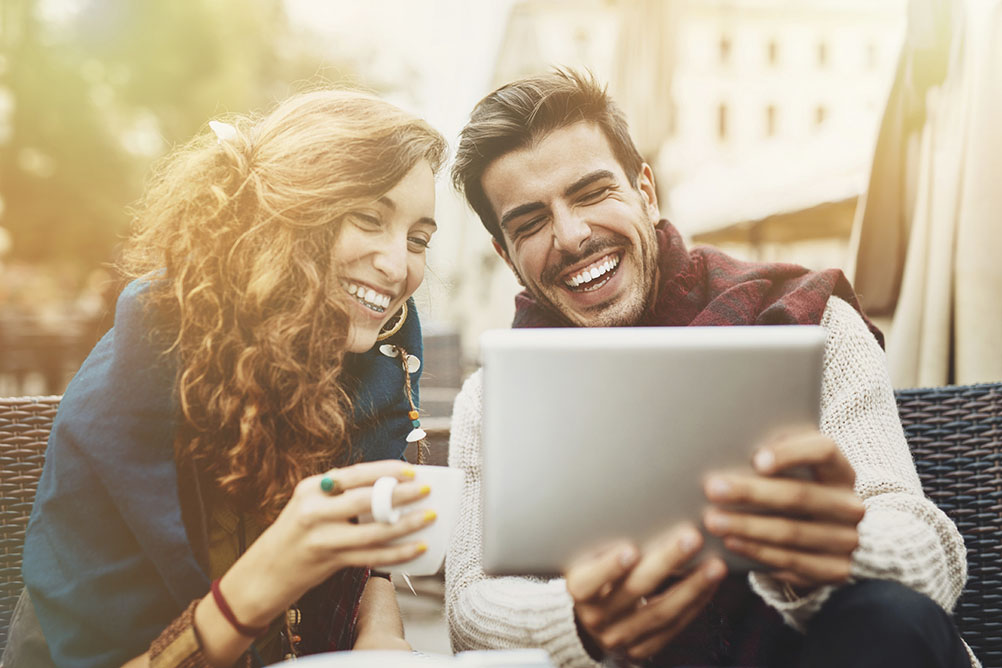 Couple smile as they look at computer screen