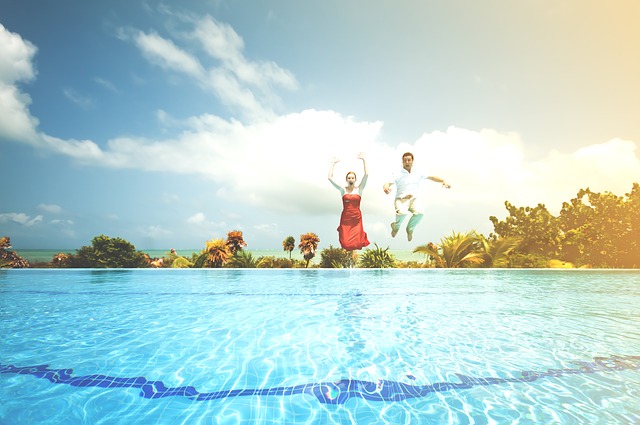 Happy couple jump into a swimming pool to celebrate their lottery win