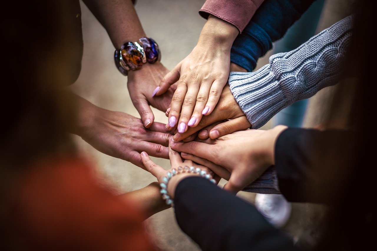 Group of lottery syndicate players join their hands together