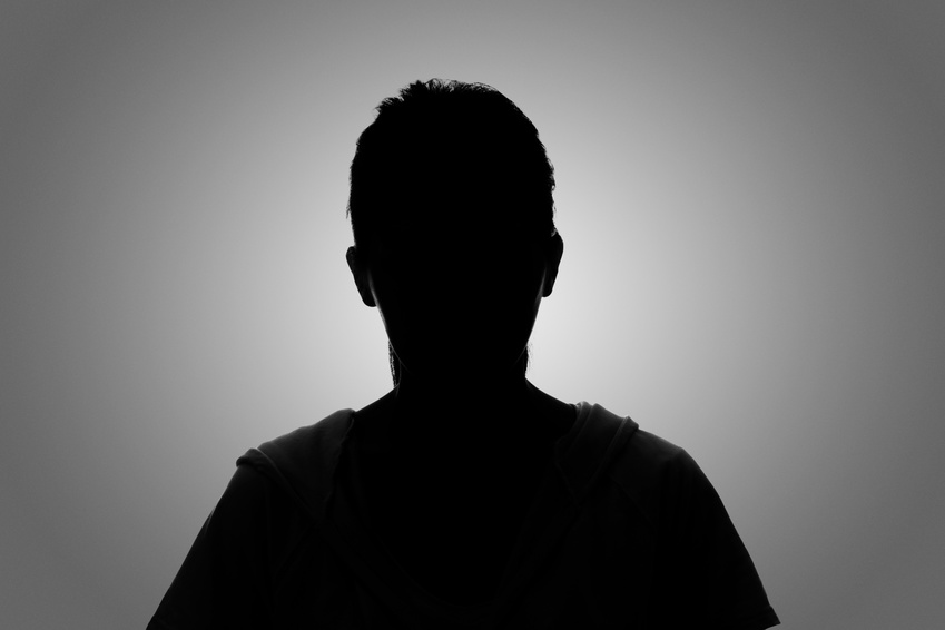 Silhouette of anonymous lottery winner against a grey background